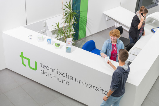 Ein Student gibt seine Wartenummer bei der Studienberatung ab.
